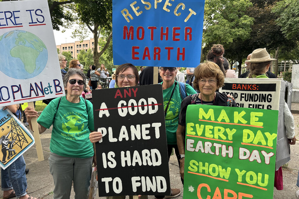 Members of Mother Earth Community holding signs and Climate March